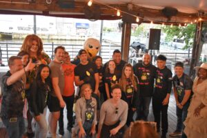 The host, judges, and winners of Guac Off 2022 pose with Swoop at Morgan's Pier